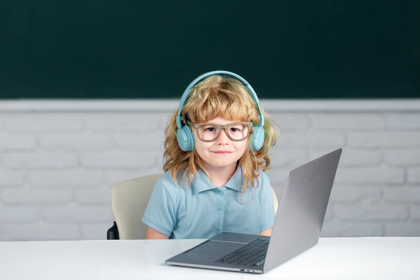Child boy in headphones study online, child in earphones take Internet web lesson. First day at school. - Фото, зображення