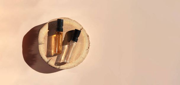 Tahta kesiminde kahverengi sıvı bulunan iki cam parfüm test eden bayrak. Üst görünüm - Fotoğraf, Görsel
