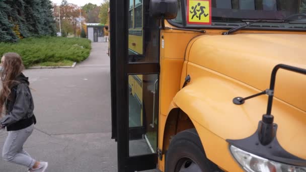 Πολυφυλετικές έφηβες με μάσκες προσώπου που φεύγουν από το σχολικό λεωφορείο - Πλάνα, βίντεο