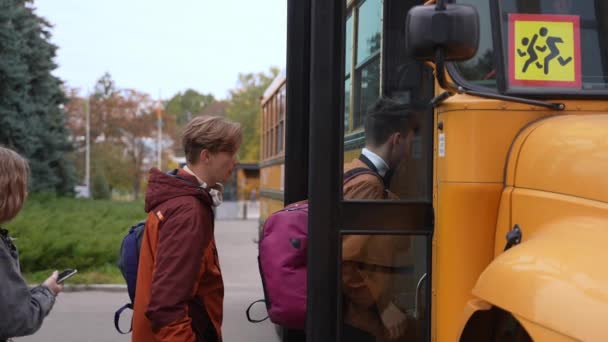Diversi studenti adolescenti che entrano in autobus dopo lo studio - Filmati, video