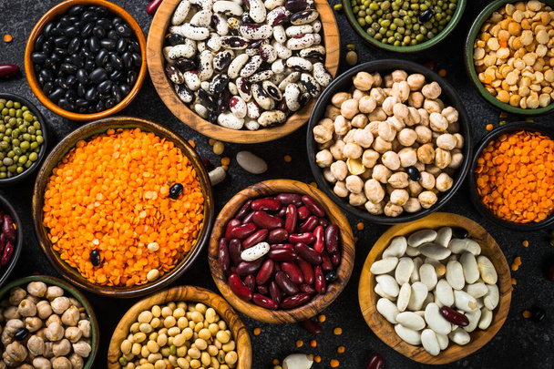Legumes, lentils, chikpea and beans assortment on black stone table. - Foto, Imagem