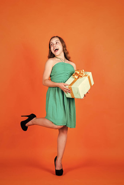 happy child with gift box on orange background, cyber monday - Foto, afbeelding
