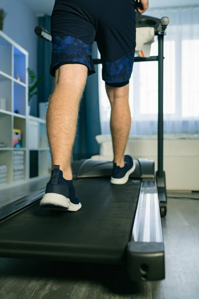 Man Treadmill Running In Home. Cardio Run Workout. Sportsman Jogging Treadmill Running. Vertical photo - Foto, imagen