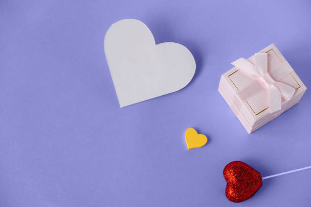 紫色の背景に空のバレンタインカードと装飾的な心を持つ小さなギフトボックス. - 写真・画像