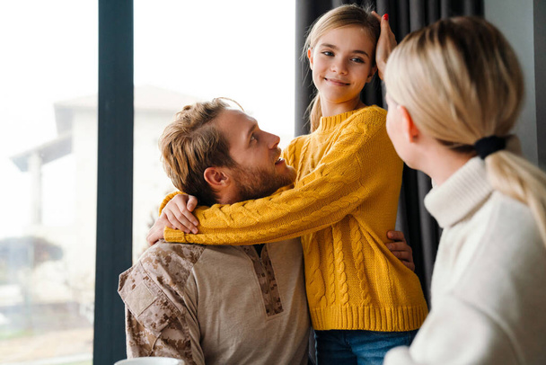 Beautiful happy family smiling and talking while hugging at home - Valokuva, kuva