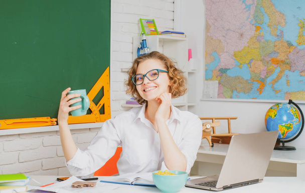 Moderner attraktiver Lehrer. Porträt eines smarten jungen Lehrers mit Brille und Buch in der Schule. Studienkonzept. - Foto, Bild