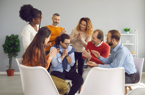 Diverse people applauding young man thanking him for being honest in group therapy - Photo, Image