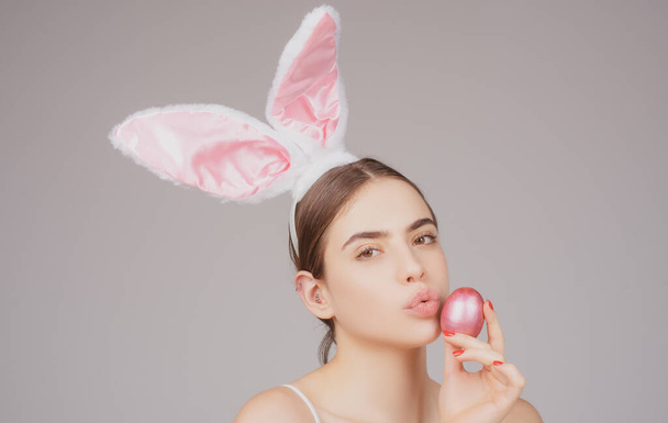 Bunny girl with easter egg. Rabbit girl with color egg. Woman in rabbit ears. Egg hunt. - 写真・画像
