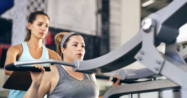 Commençons.... Plan recadré d'une femme instructrice de conditionnement physique emmenant son client à travers une séance d'entraînement dans la salle de gym. - Photo, image