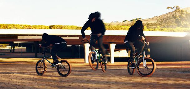 完璧なトリックを着陸させる。街中でトリックをやって若い男性BMXライダーの完全な長さのショット. - 写真・画像