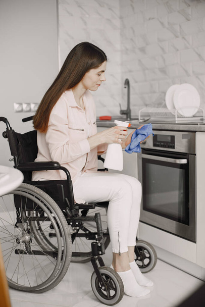 Young Handicapped Woman On Wheelchair Cleaning Stove - Foto, afbeelding