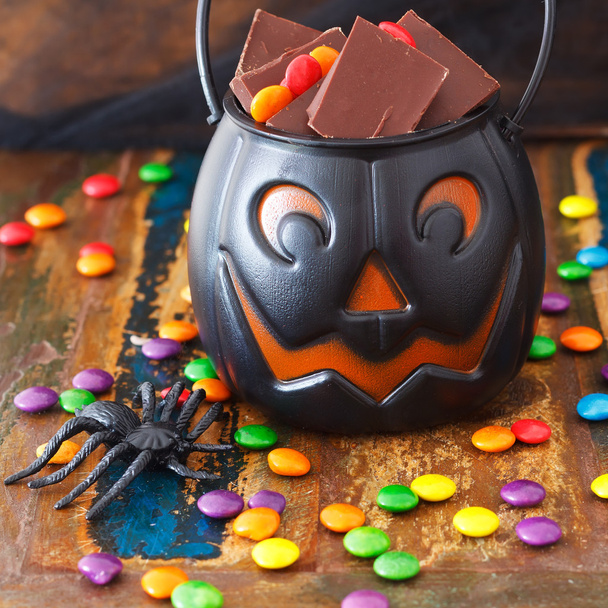Halloween Sweets chocolate candy in pumpkin bowl, spide - Fotografie, Obrázek