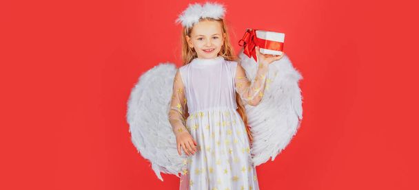 Angel children girl with white wings Cute baby child with angel wings. Angel kids with present gift, studio portrait. Little blonde angel with white wings holds gift. Valentines day, banner. - Zdjęcie, obraz