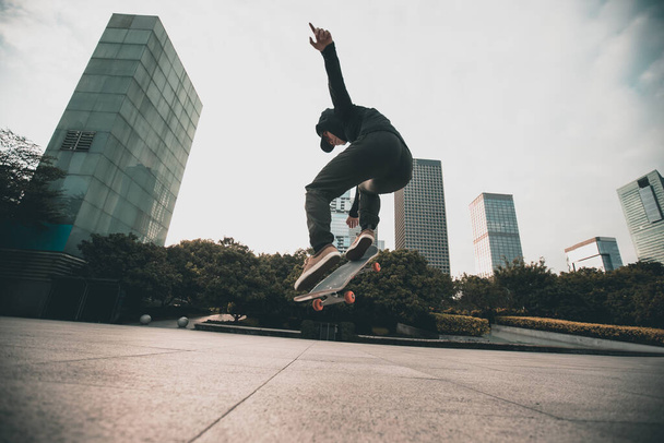 Skateboarder skateboarding al aire libre en la ciudad - Foto, Imagen