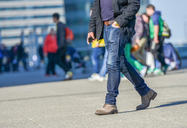 Legs of a young person walking on a busy street - Photo, image
