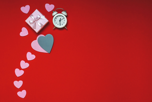 Sevgililer Günü için çalışma alanının en üst görünümü kırmızı arka plan, kalp hediyeleri ve çalar saat üzerine yatıyordu, kopyalama alanı. - Fotoğraf, Görsel