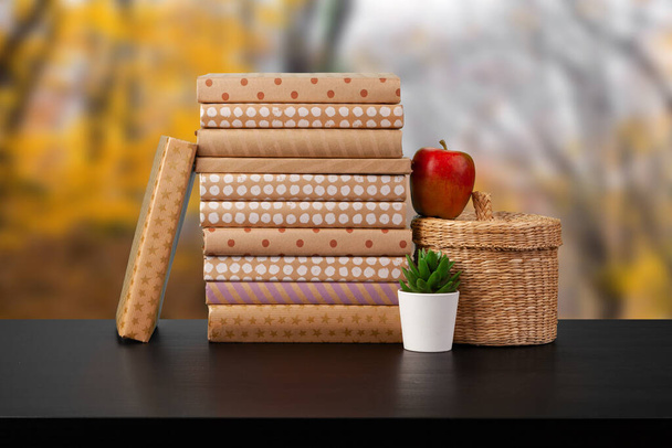 Stack of books on wooden table against blurred background - Foto, Imagen