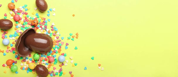Шоколадні великодні яйця з цукерками та зморшками на жовтому тлі з місцем для тексту
 - Фото, зображення