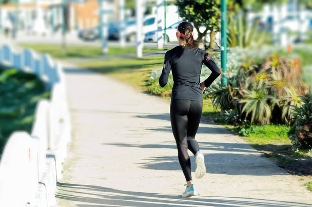 Atleta in nero in allenamento corsa nel parco - Foto, immagini