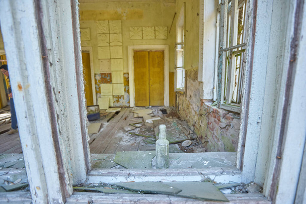 Csernobil közelében, elhagyatott kultúrház a faluban, kilátás a betört ablakon keresztül - Fotó, kép