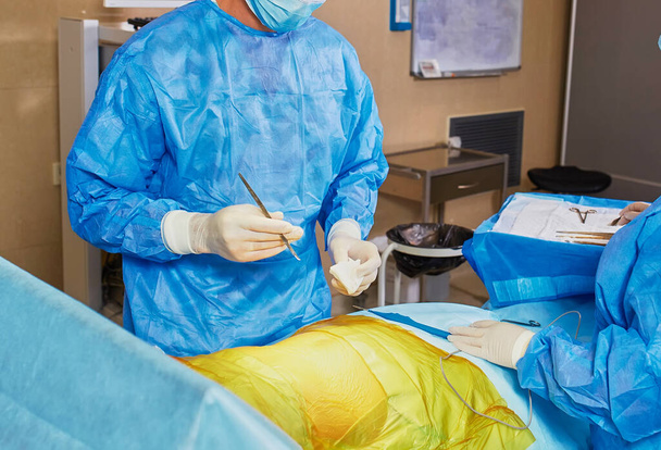 Sairaalassa olevien kirurgien ryhmä tekee minimaalisia invasiivisia kirurgisia toimenpiteitä. Leikkaus leikkaussali sähköpoltin laitteet sydän- ja verisuonitautien hätäkirurgia keskus. - Valokuva, kuva