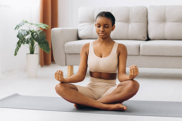 若い黒人女性瞑想自宅で、ヨガのオンラインコンセプト、フリースペース - 写真・画像
