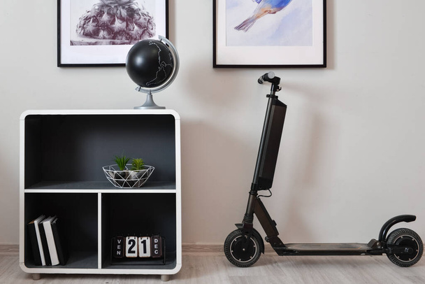 Стильный интерьер минималистского номера с электрическим скутером, полкой и декором - Фото, изображение