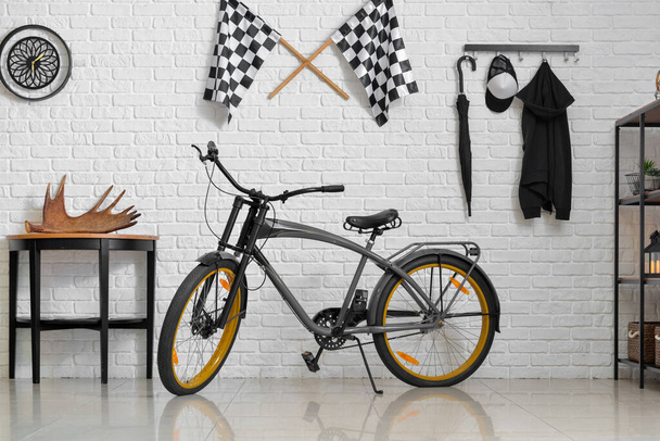Стильний інтер'єр кімнати з сучасним велосипедом і світлою цегляною стіною
 - Фото, зображення
