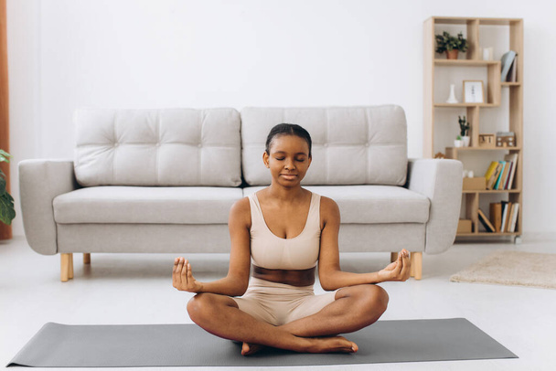 Young black woman meditating at home, yoga online concept, free space - Fotografie, Obrázek
