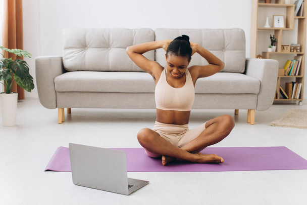 Allenamento domestico. Giovane donna nera sportiva che fa esercizio Plank a casa, formazione in salotto - Foto, immagini