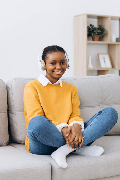 Jonge Afro-Amerikaanse vrouw in gesprek op video in de woonkamer thuis, afstandsonderwijs concept van thuis. - Foto, afbeelding