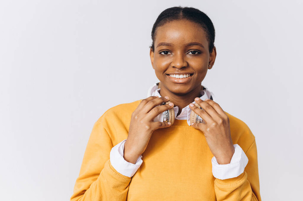 Joven mujer afroamericana positiva alegre usa auriculares inalámbricos estéreo escucha la pista de audio. Gente emociones felices y concepto de ocio - Foto, imagen