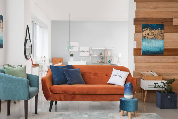 Интерьер современной гостиной со стильным коричневым диваном - Фото, изображение