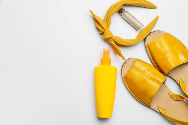 Bottle of sunscreen and beach accessories on white background - Fotó, kép