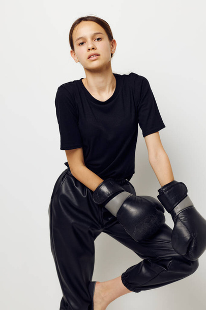 beautiful girl in boxing gloves in black pants and a T-shirt Lifestyle unaltered - Фото, изображение