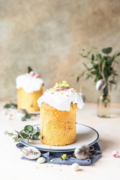 Easter composition with traditional Orthodox sweet bread. Kulich decorated with meringue icing, sugar sprinkles and eucalyptus. - Fotoğraf, Görsel