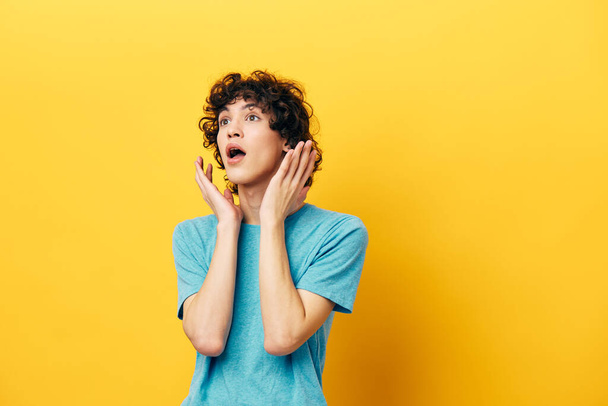 guy on a yellow background in a blue t-shirt emotions - Foto, Imagem