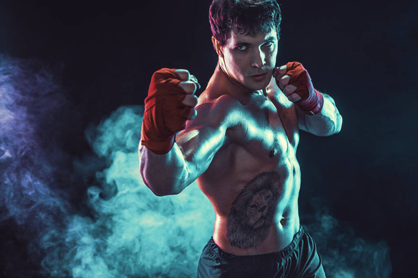 Half length of aggressive shirtless boxer who preparing for fight on smoke background. Sport concept - Foto, afbeelding