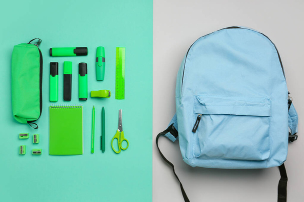 Комплект различных канцелярских принадлежностей с рюкзаком на цветном фоне - Фото, изображение