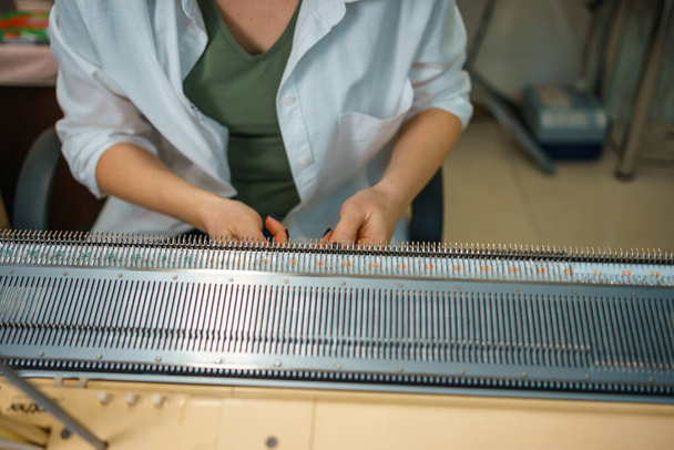 la personne est engagée dans le tricotage sur une machine à tricoter domestique. travail manuel. fait à la main. Photo de haute qualité - Photo, image