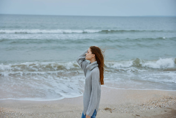 красивая женщина в одиночестве у океана облачно погода неизменна - Фото, изображение