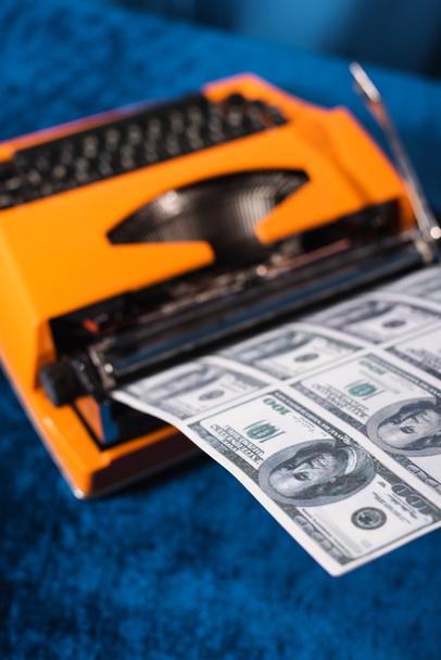 korkea kulma näkymä hämärtynyt vintage kirjoituskoneen ja dollarin seteleitä sininen pöytä - Valokuva, kuva