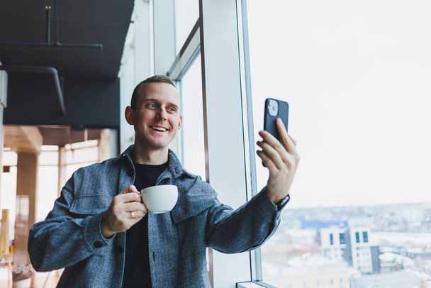 Nadšený mladý muž v obleku pomocí mobilního telefonu s legračním výrazem, vzrušený obchodník při pohledu na jeho smartphone, čtení dobré zprávy prostřednictvím e-mailu, emocionální životní styl koncept. - Fotografie, Obrázek