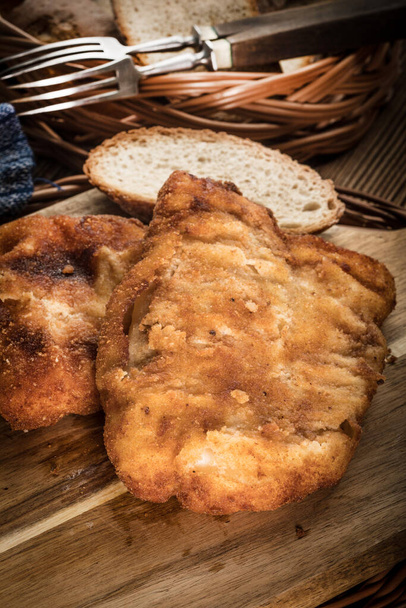 Cod fillet fried in breadcrumbs on a chopping board. - Foto, imagen