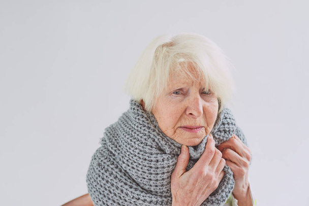старша хвора жінка в шарфі замерзає вдома. Охорона здоров'я, криза, концепція старіння
 - Фото, зображення