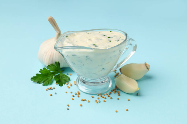 Salsa de ajo e ingredientes sobre fondo azul - Foto, Imagen