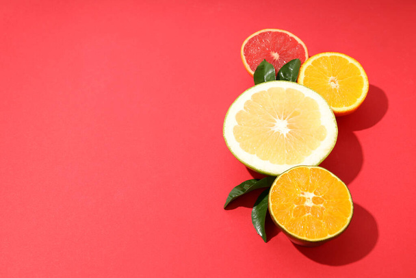 Kırmızı arkaplanda turunçgil meyveleri, metin için boşluk - Fotoğraf, Görsel