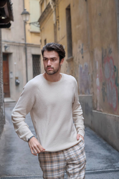 レッジョ・エミリアの中心に白いセーターを着た美しい男。高品質の写真 - 写真・画像