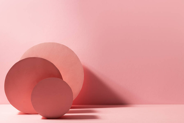 Fashion minimal contrast pink stage in modern style with round boxes standing as abstract composition in sunlight with shadows, copy space. Scene for presentation products, advertising, design. - Zdjęcie, obraz