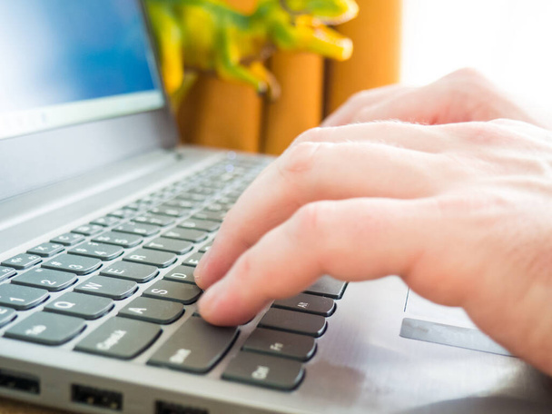 Close-up beeld van mannelijke handen typen op laptop toetsenbord en surfen op het internet op afstand werk concept - Foto, afbeelding